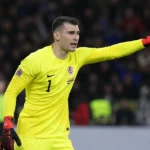 Dominik Livakovic in geel doelmannenpak tijdens een voetbalwedstrijd.