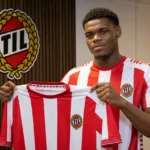 Vince Osuji toont een Tromsø IL-shirt tijdens een officiële clubpresentatie.