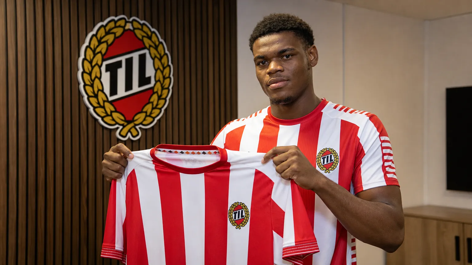 Vince Osuji toont een Tromsø IL-shirt tijdens een officiële clubpresentatie.