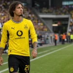 Fabio Silva in het tenue van Borussia Dortmund langs de zijlijn van een voetbalveld.