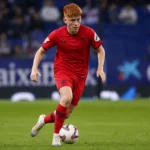 Voetbalpersbeeld van een speler in een stadiontunnel.