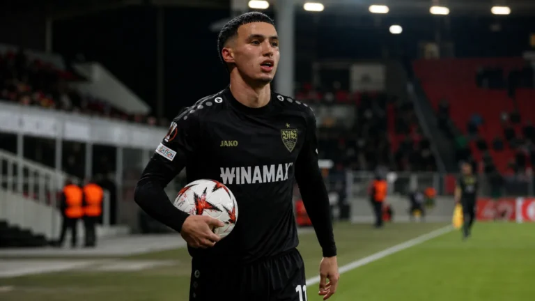 Bilal El Khannouss in een donker voetbaltenue langs de zijlijn van een stadion.