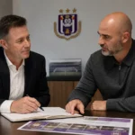 Twee clubverantwoordelijken van RSC Anderlecht in gesprek in een vergaderruimte.
