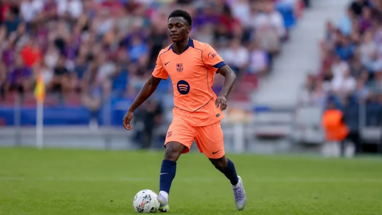 Jesse Bisiwu in een oranje Barcelona-tenue tijdens een voetbalactie op het veld.