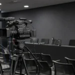 Een actieve Club Brugge-mediaruimte met camera-apparatuur en een discreet clubdetail aan de wand.