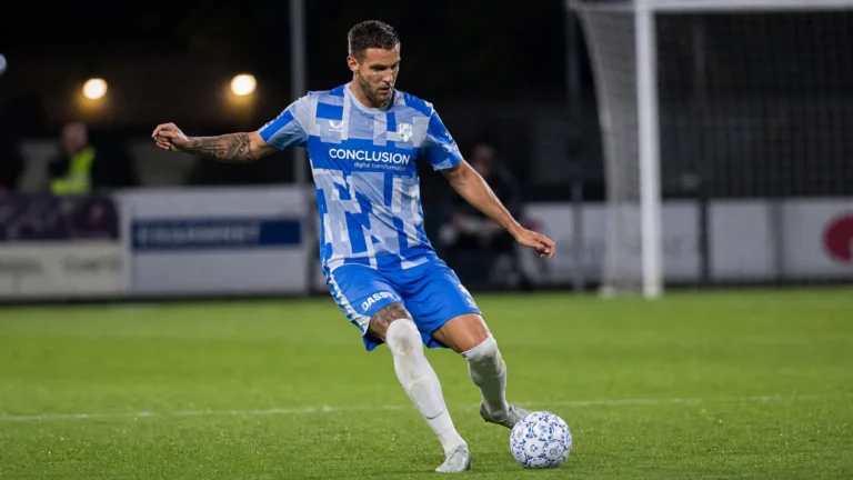 Mike Eerdhuijzen in actie als verdediger van FC Utrecht op een verlicht voetbalveld.