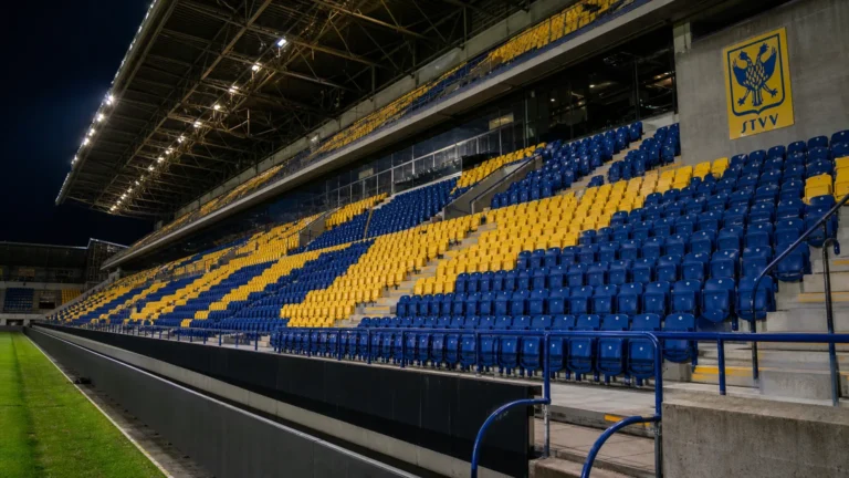 Een lege tribunesectie met nieuwe blauwe en gele zitjes in het stadion van STVV.