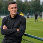Aleksander Stanković in neutrale sportkleding aan de rand van een trainingsveld.