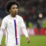 Malick Fofana wandelt na een Europese wedstrijd over het veld in een wit shirt.