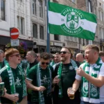 Een groep Hibernian-supporters in groen-witte kleding verzamelt in het centrum van Gent.
