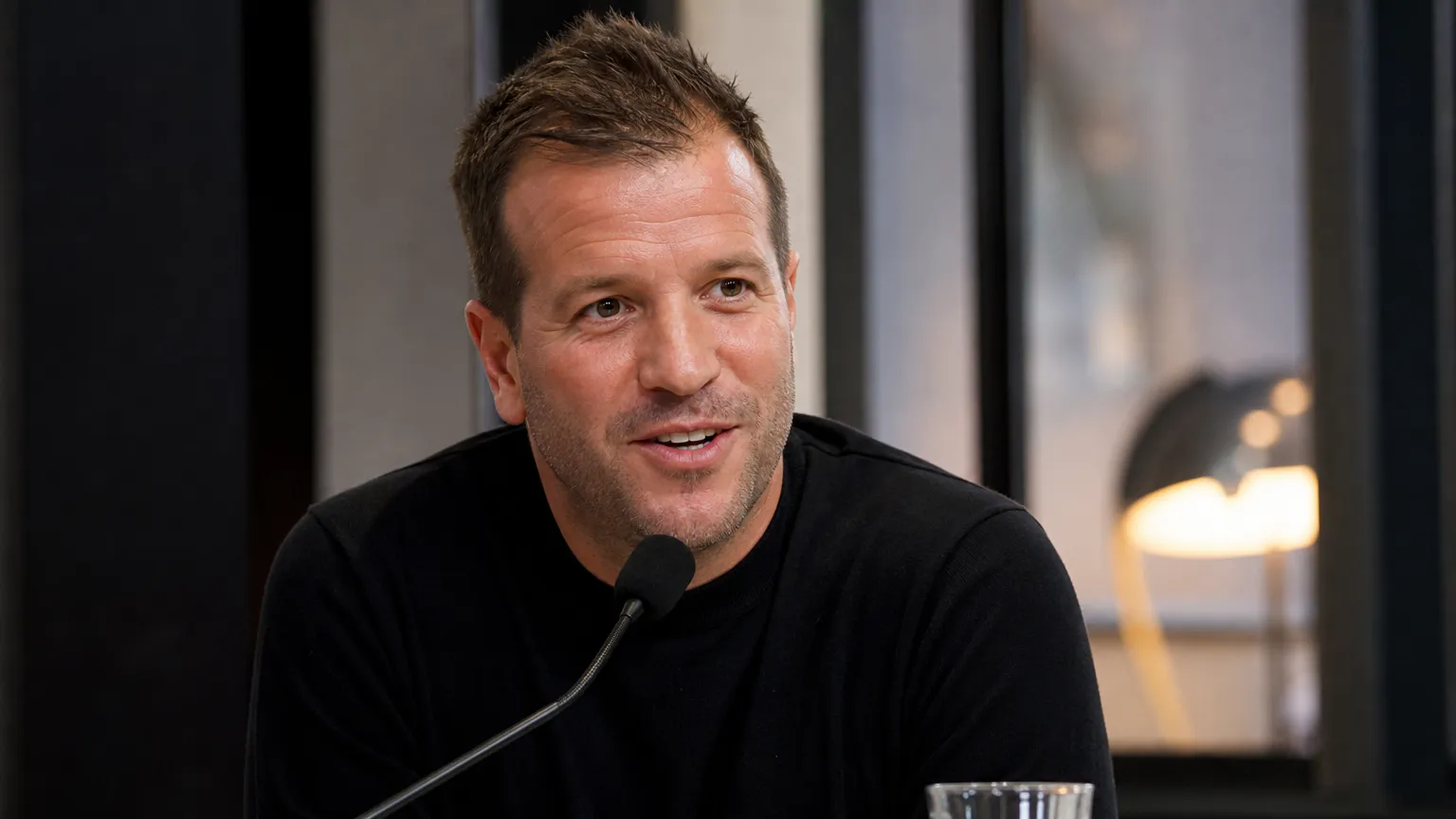 Rafael van der Vaart spreekt aan een microfoon tijdens een televisie-interview.