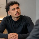 Tristan Gooijer in neutrale kleding tijdens een rustig gesprek in een ontvangstruimte.