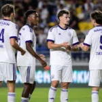 Anderlecht-spelers in witte wedstrijdtenues groeperen zich tijdens een Europese uitwedstrijd.