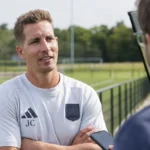Jelle Coen spreekt langs een oefenveld van Anderlecht.