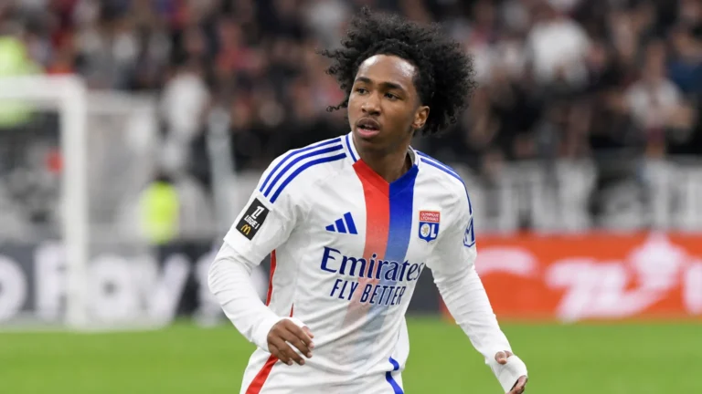 Malick Fofana in een wit Lyon-shirt tijdens een voetbalmoment op het veld.