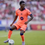Jesse Bisiwu in een oranje FC Barcelona-tenue tijdens een voetbalactie.
