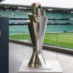 De Nations League-trofee op een display in een stadionomgeving.