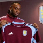 Aaron Wan-Bissaka toont het shirt van Aston Villa tijdens zijn officiële voorstelling.