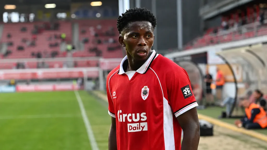 Jules Ahoka in het rood van Royal Antwerp FC langs de zijlijn van een stadion.