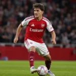 Christos Tzolis in Arsenal-tenue tijdens een dribbel op het veld.