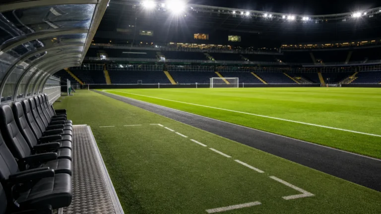 Een verlicht Europees voetbalveld met technische zone voor een returnwedstrijd.