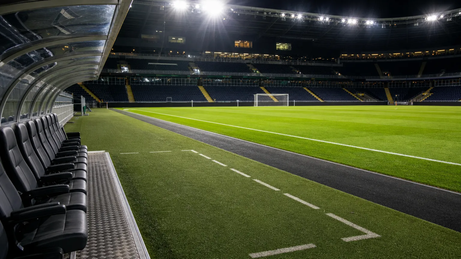 Een verlicht Europees voetbalveld met technische zone voor een returnwedstrijd.