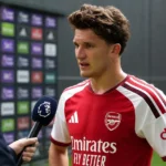Christos Tzolis van Arsenal spreekt na een wedstrijd in zijn rood-witte wedstrijdshirt.