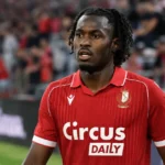 Ibrahim Karamoko staat na de wedstrijd aan de rand van het veld in een rood wedstrijdshirt.