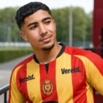Moncef Zekri in het rood-geel gestreepte tenue van KV Mechelen aan een voetbalcomplex.