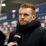 Edward Still tijdens een interview na de wedstrijd in een stadionomgeving.