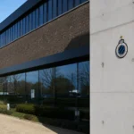 De buitenzijde van een Club Brugge-clubgebouw met een discreet clubembleem.