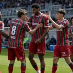 Een groep spelers van Zulte Waregem viert samen op het veld tijdens een wedstrijd.