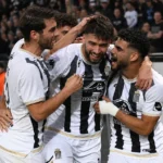 Spelers van Sporting Charleroi vieren samen een doelpunt aan de zijlijn.