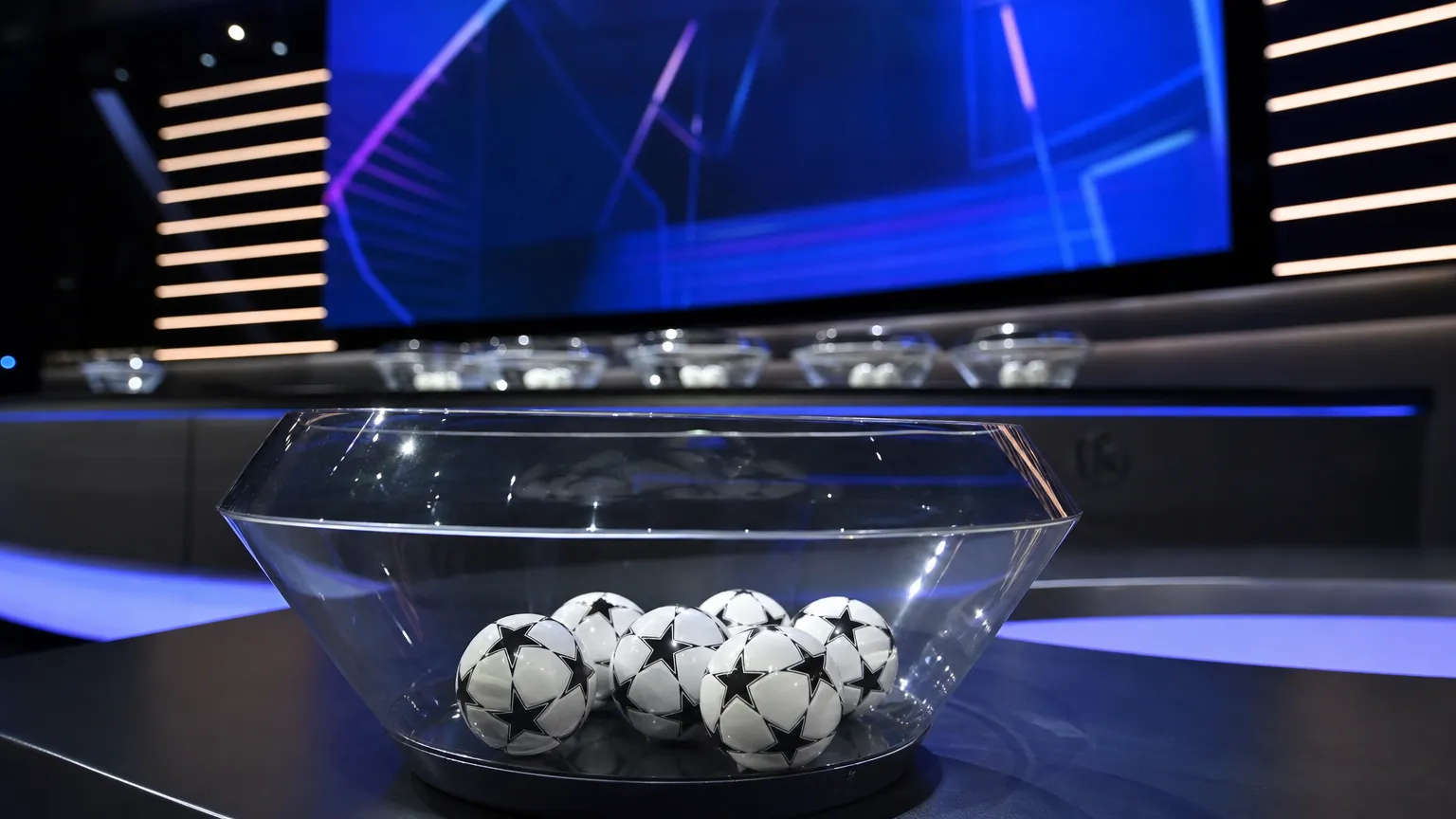 Genummerde lotingsballen op een tafel in een officiële Conference League-lotingsruimte.