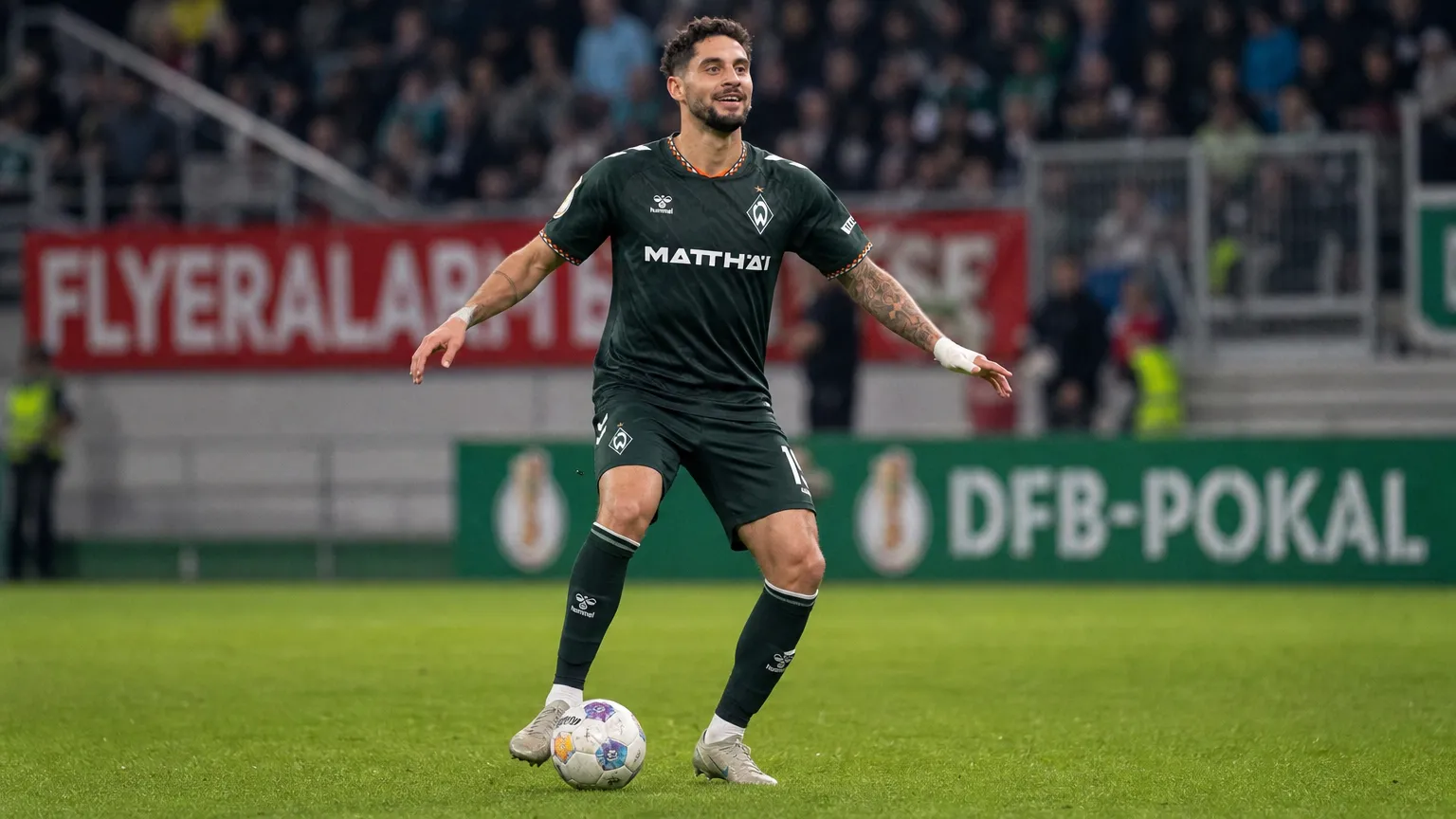 Ludovit Reis in het donker wedstrijdshirt van Werder Bremen tijdens een bekerwedstrijd.