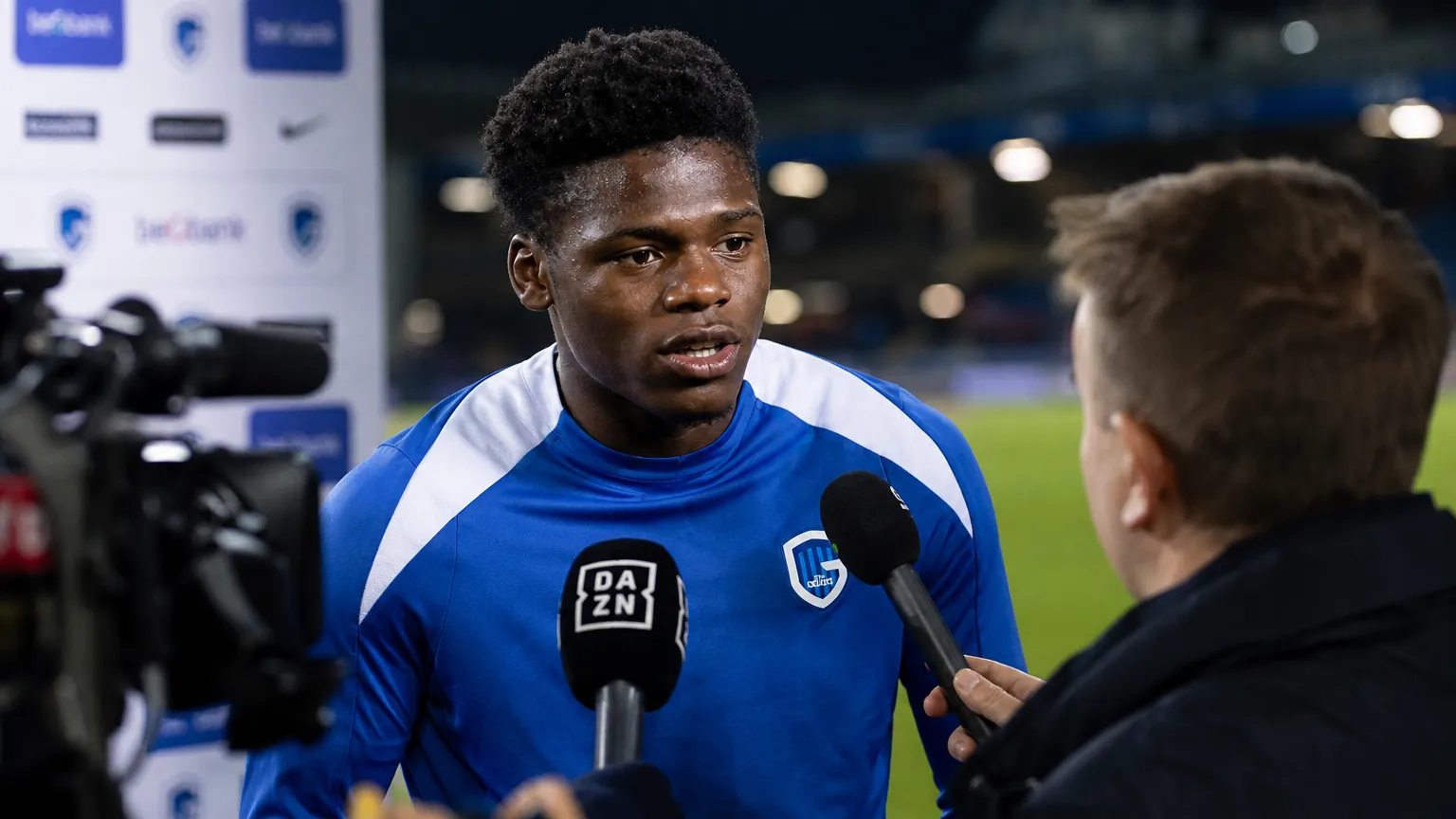 Josué Kongolo van KRC Genk praat na de wedstrijd met journalisten naast het veld.