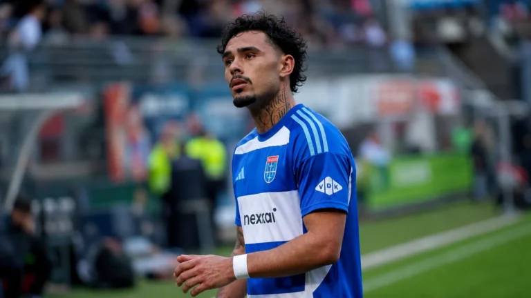 Tristan Gooijer in een blauw voetbalshirt langs de rand van een veld.