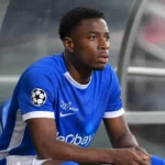 Rafiu Durosinmi van KRC Genk zit op de invallersbank en kijkt naar het veld.