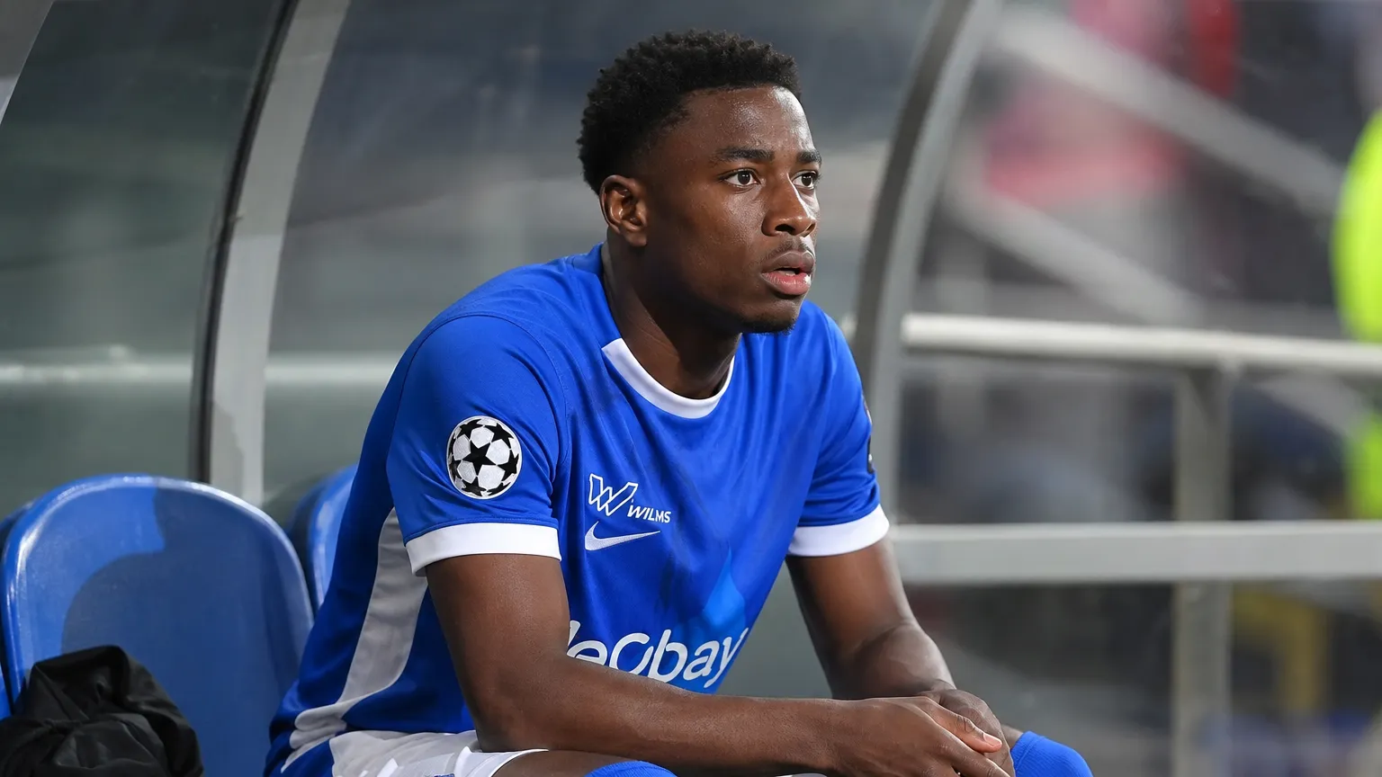 Rafiu Durosinmi van KRC Genk zit op de invallersbank en kijkt naar het veld.