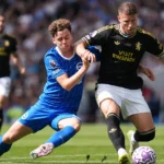 Twee spelers vechten om positie tijdens een Premier League-wedstrijd.