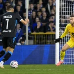 Een aanvaller en doelman in actie voor het doel tijdens de Brugse derby.