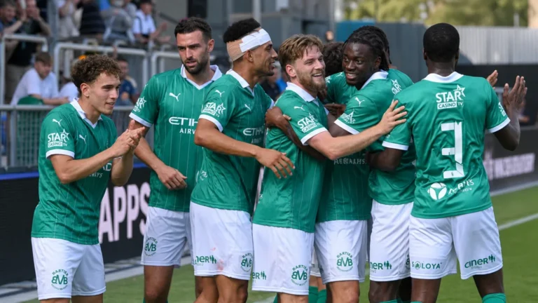 Een groep Lommel-spelers viert samen naast het veld na een thuiswedstrijd.