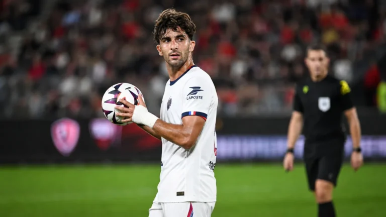 Een PSG-speler in wit tijdens een wedstrijdmoment met de bal in de handen.