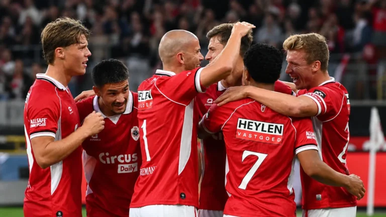 Een groep spelers van Royal Antwerp FC viert samen op het veld.
