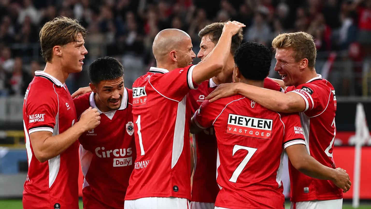 Een groep spelers van Royal Antwerp FC viert samen op het veld.