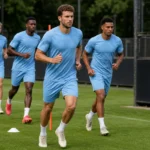Spelers trainen op het oefenveld van Feyenoord naast een discreet clubbord.