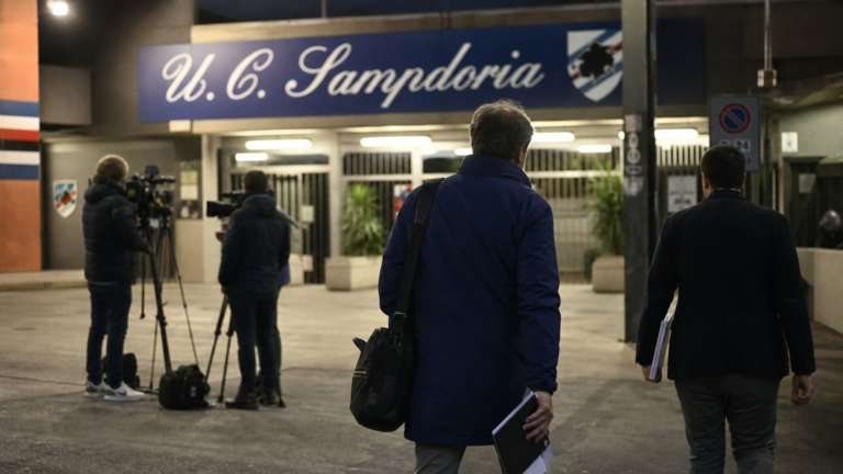 Anonieme medewerkers bij de ingang van een stadion in Genua.