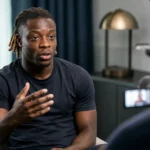 Jérémy Doku tijdens een opgenomen voetbalinterview in een rustige studiokamer.