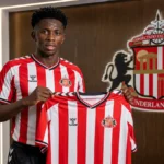 Jules Ahoka toont een Sunderland-shirt tijdens een officiële clubpresentatie.