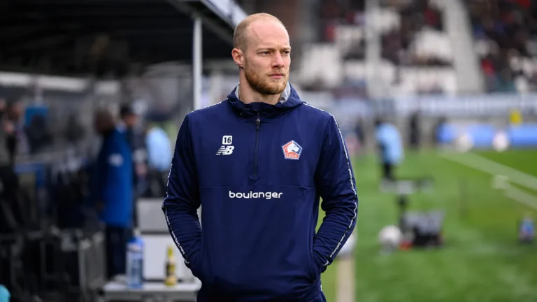 Arnaud Bodart in een donkerblauw trainingsjack langs het veld voor een wedstrijd.